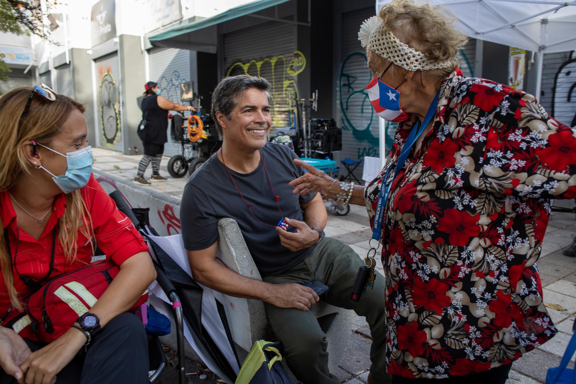 Actor Esai Morales, center, chats between scenes as the film shoots on location in San Juan.