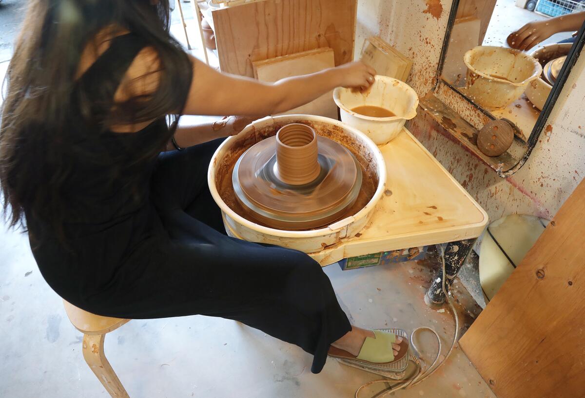 Sammy Chou works on a mug on her "wheel" at the Lunch Time Ceramics studio in Costa Mesa.