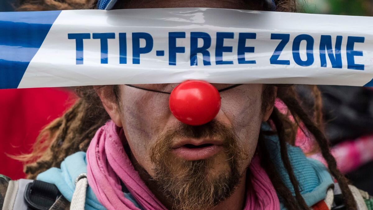 A man protests against international trade agreements in front of EU headquarters in Brussels on Oct. 27, 2016.