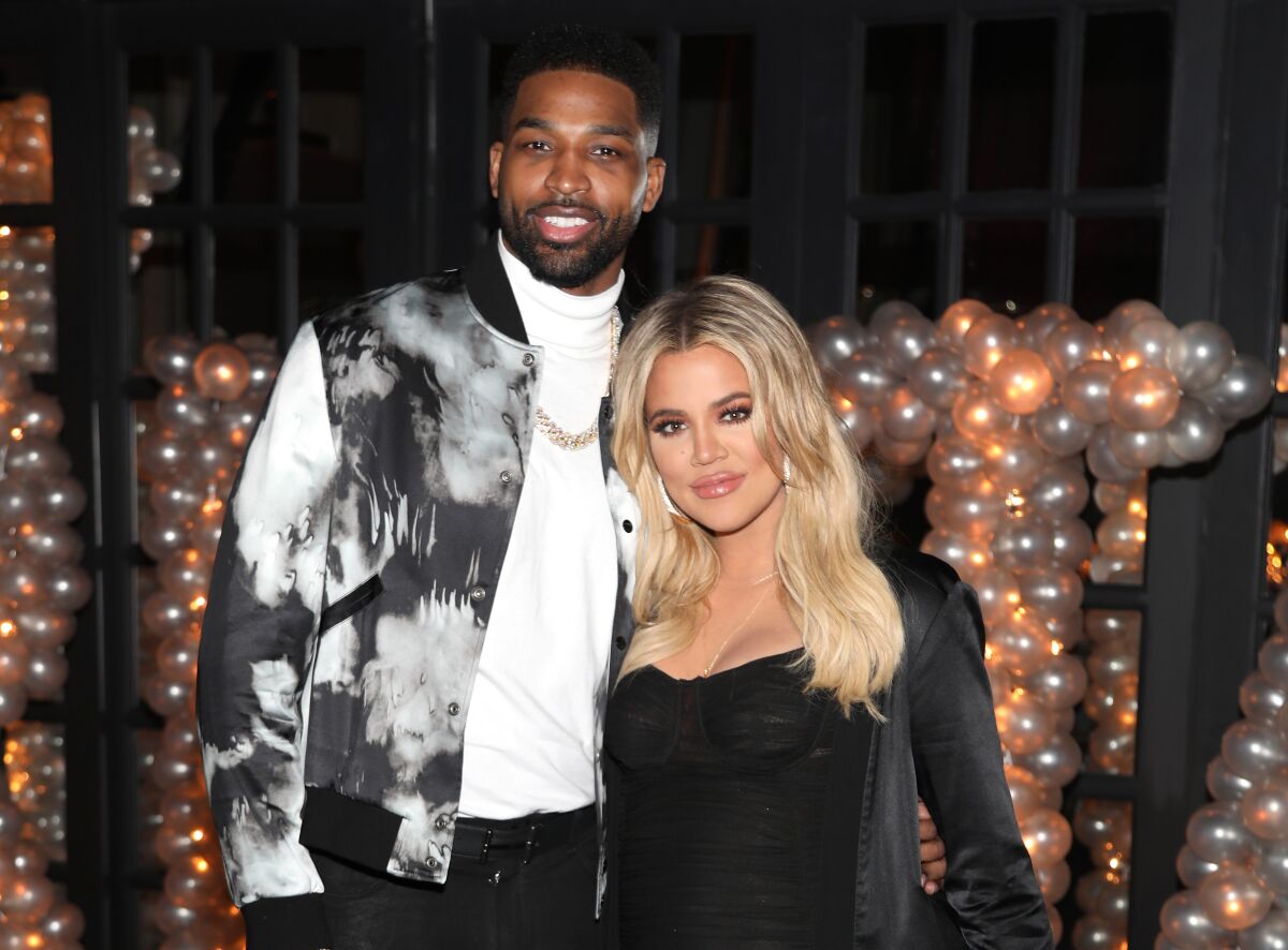 Tristan Thompson and Khloé Kardashian pose for a photo at a glitzy party.
