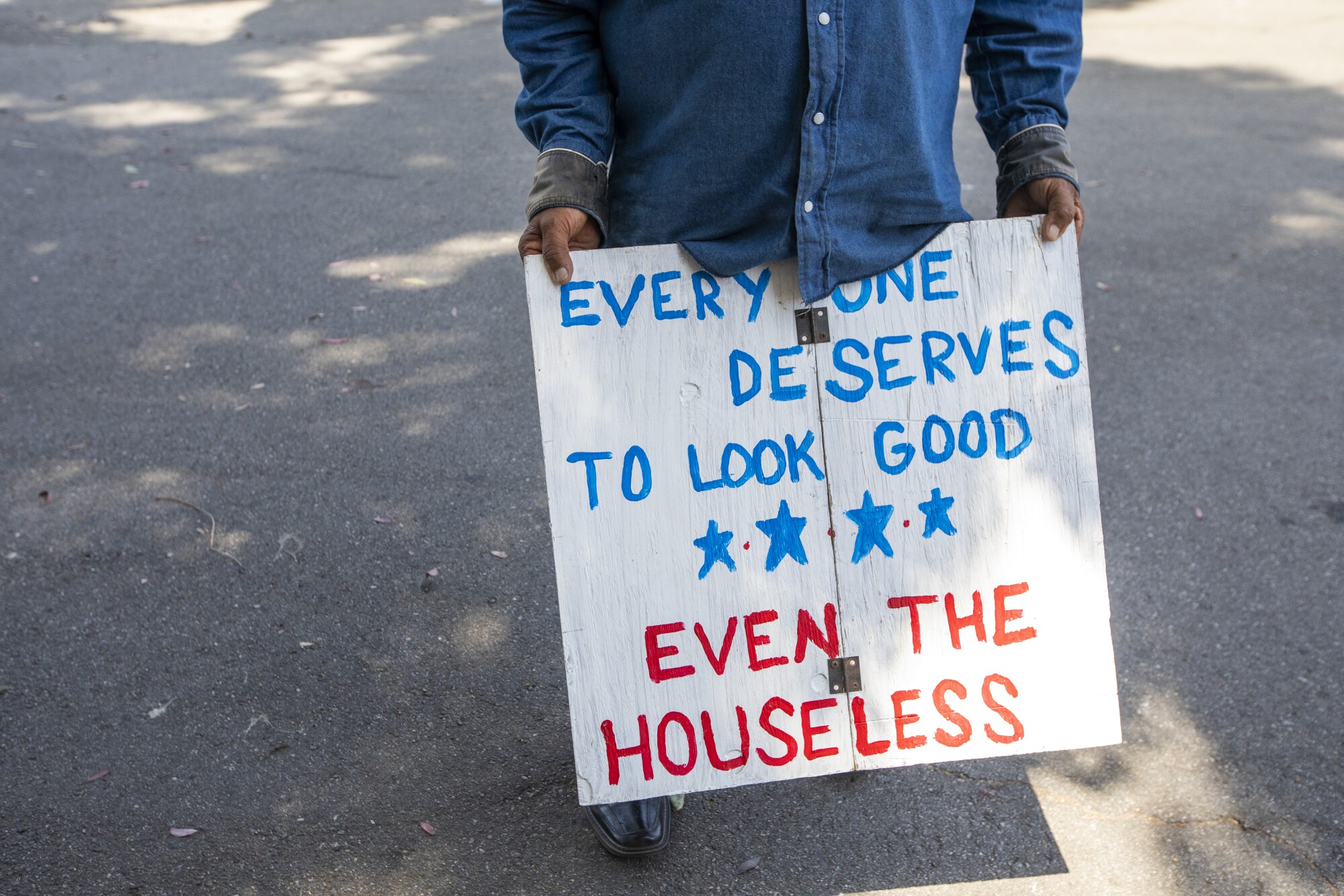 Bravo holds a sign as he waits for customers.
