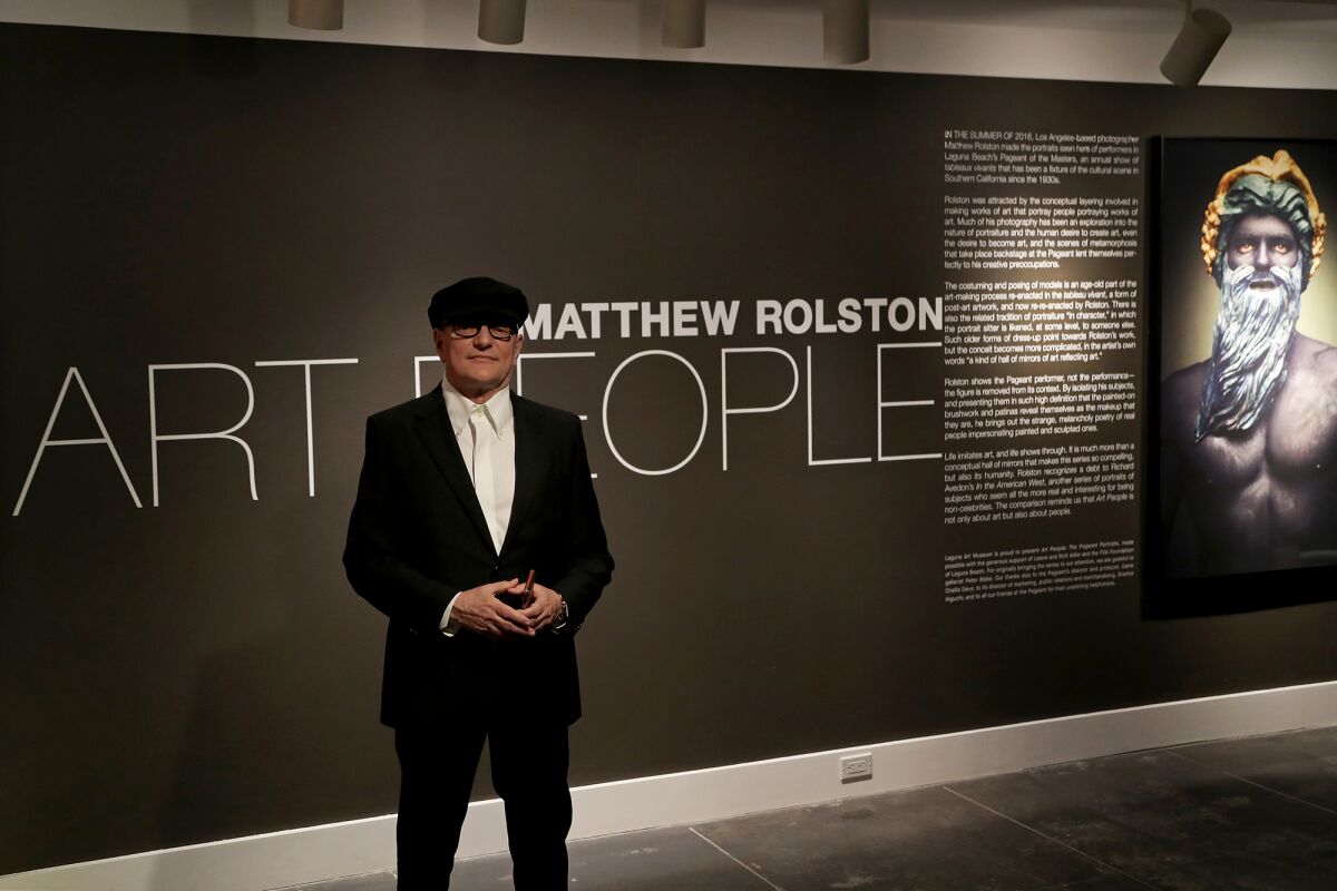 Photographer Matthew Rolston poses in front of his exhibit, "Art People: The Pageant Portraits." 