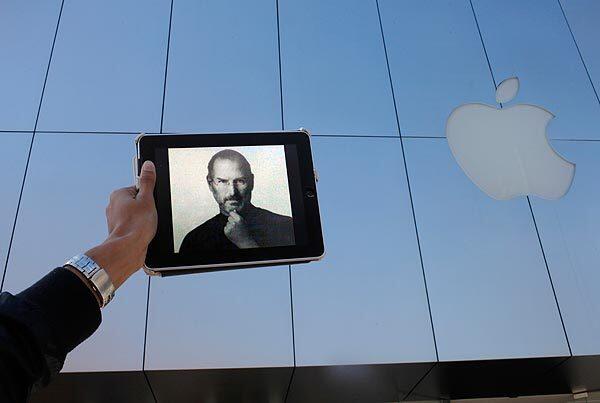 At the Apple store in Santa Monica, a man holds an iPad withSteve Jobs' image on the screen.