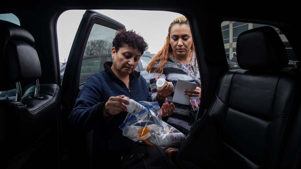 Lourdes Cristina Pacheco, left, the mother of Luis Ugalde-Pacheco, and Elida Arriaga, his girlfriend, pack clothing and medicine to take to him at the Jerome Combs Detention Center in Kankakee, Ill., on April 18.