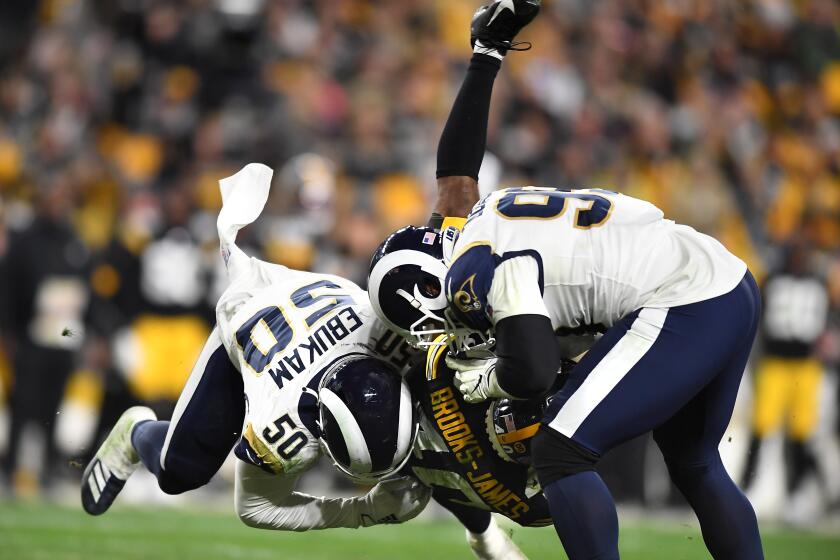 PITTSBURGH, PENNSYLVANIA NOVEMBER 10, 2019-Rams linebacker Samson Ebukam (50 and defensive tackle Aaron Donald bring down Steelers running back Tony Brooks-James in the 4th quarter at Heinz Field in Pittsburgh Sunday. (Wally Skalij/Los Angerles Times)