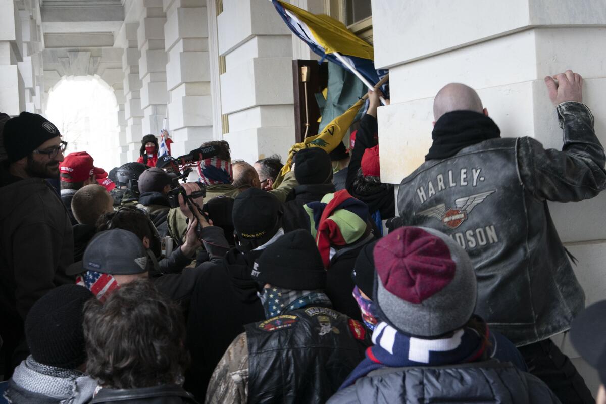 Rioters try to open a door at the Capitol on Jan. 6.
