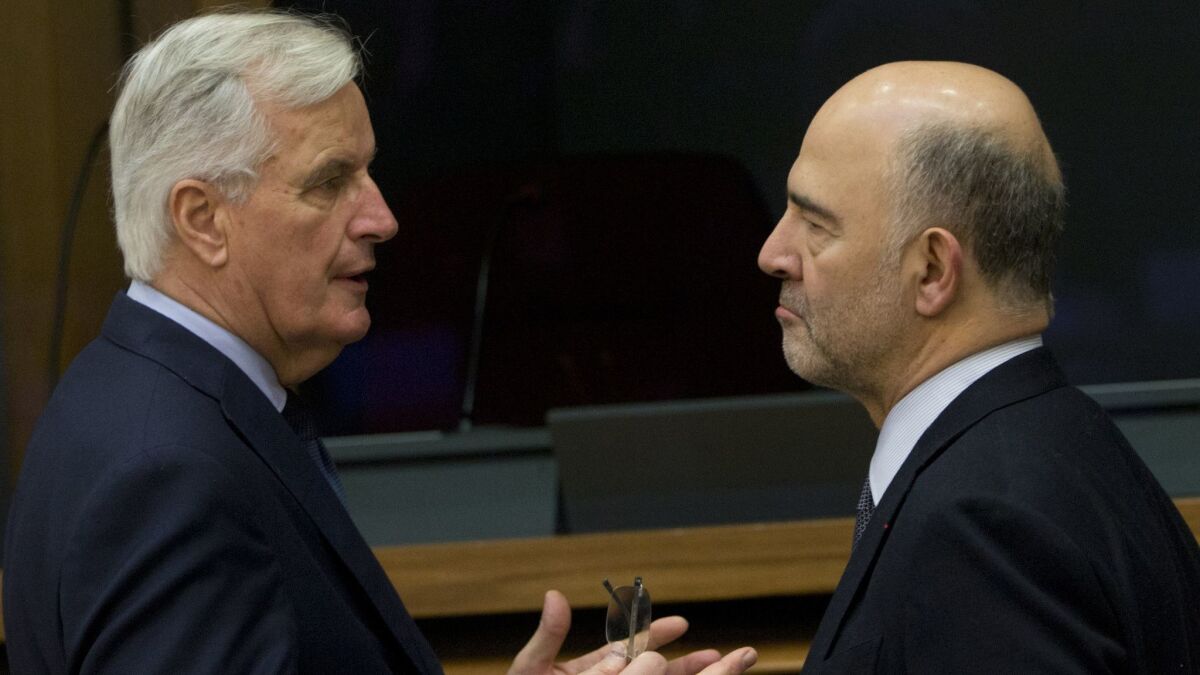 European Union chief Brexit negotiator Michel Barnier, left, speaks with European Commissioner for Economic and Financial Affairs Pierre Moscovici during a meeting of the College of Commissioners at EU headquarters in Brussels on Dec. 19, 2018.
