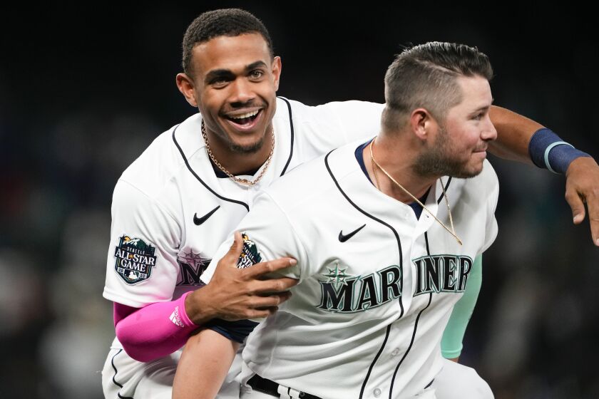 Seattle Mariners' Julio Rodriguez, left, jumps on teammate Ty France as they celebrate beating the New York Yankees on a walk-off single from Cal Raleigh during the 10th inning of a baseball game Wednesday, May 31, 2023, in Seattle. (AP Photo/Lindsey Wasson)
