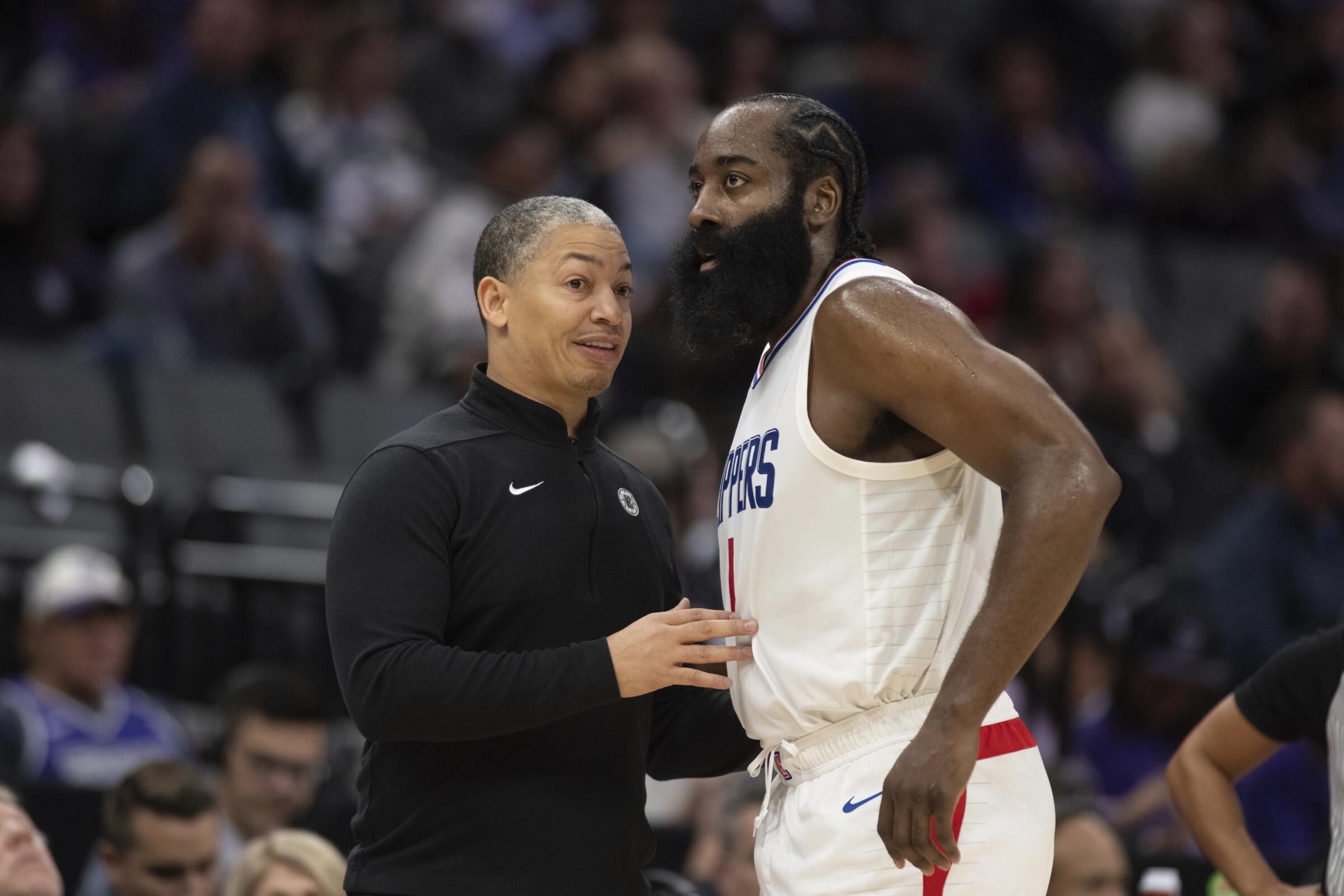 Clippers coach Tyrone Lue talks with guard James Harden during the game.