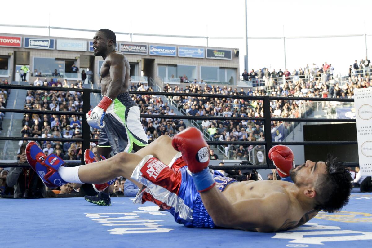 Andre Berto walks to his corner after knocking down Victor Ortiz, foreground, during the fourth round of a welterweight boxing match, Saturday, April 30, 2016, in Carson, Calif. Berto won by knockout in the fourth round. (AP Photo/Jae C. Hong)