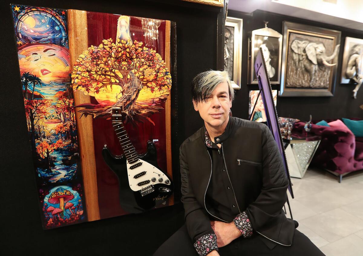 Fine artist and art consultant David Michael Vaughn with his mixed-media "Guitar Way to Heaven" piece.