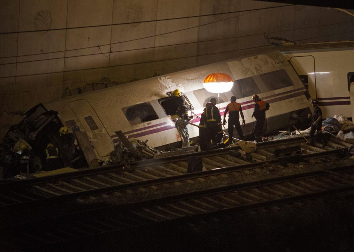 FILE - Emergency personnel work at the site of a train which was derailed in Santiago de Compostela, Spain, on Thursday, July 25, 2013. A trial has begun in Spain on Wednesday Oct. 5, 2022 for the 2013 train accident that killed 80 passengers and injured 145 others. Prosecutors are seeking four-year prison sentences for the train driver and for a former security director at the rail infrastructure company, ADIF after the long-distance train derailed and crashed against a concrete wall while traveling over the speed limit. (AP Photo/ Lalo Villar, File)