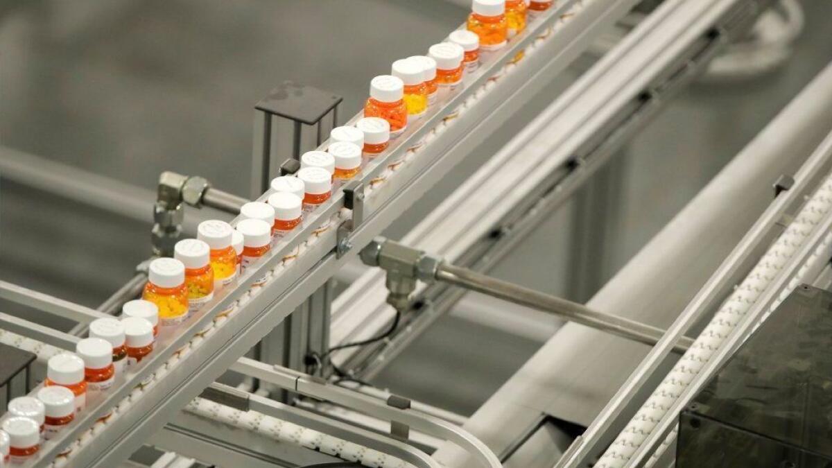 Bottles of medicine ride on a belt at the Express Scripts mail-in pharmacy warehouse in Florence, N.J.