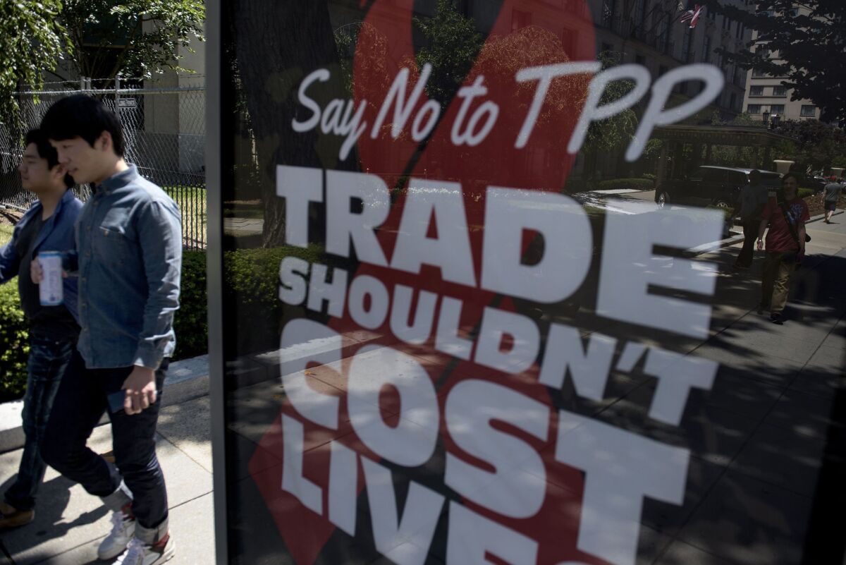 People pass an advertisement in Washington, D.C., protesting the Trans-Pacific Partnership.