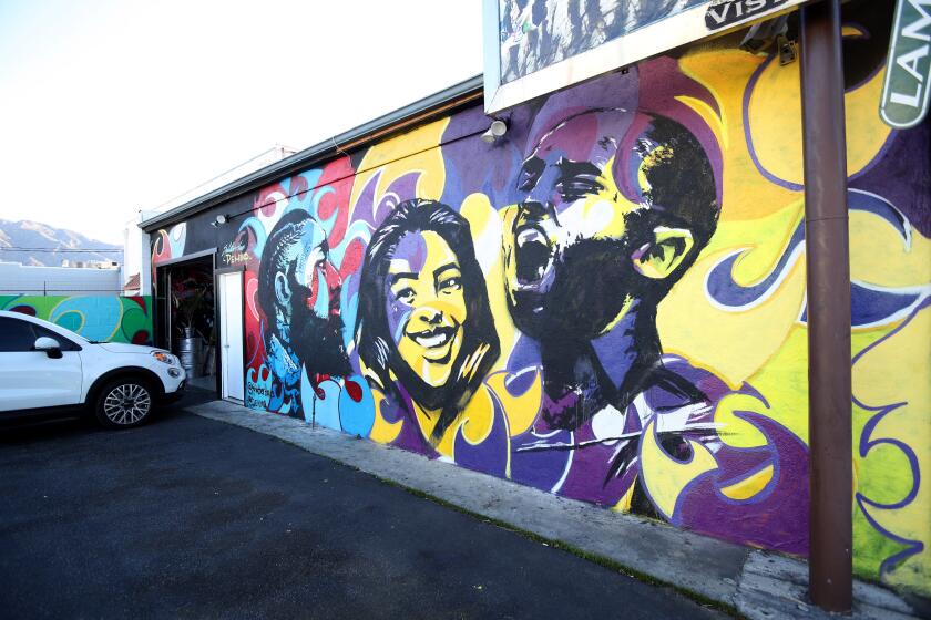 Local artists Arthur Akopyan and Haibert Sarkissian created a mural on the SplatterHaus building, commemorating the late Kobe and Gigi Bryant as well as rapper Nipsey Hussle, in Burbank on Tuesday, Feb. 11, 2020.