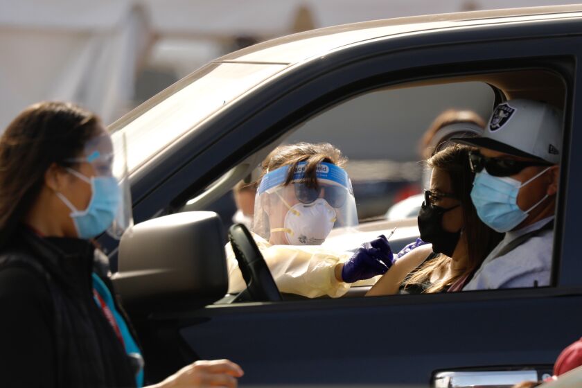 INGLEWOOD CA JANUARY 19, 2021 - Drivers pull up to a mass vaccination site in the parking lot of The Forum in Inglewood. The Forum, is one of five mass-vaccination sites opening Tuesday, January 19, 2021 in the county. (Al Seib / Los Angeles Times)