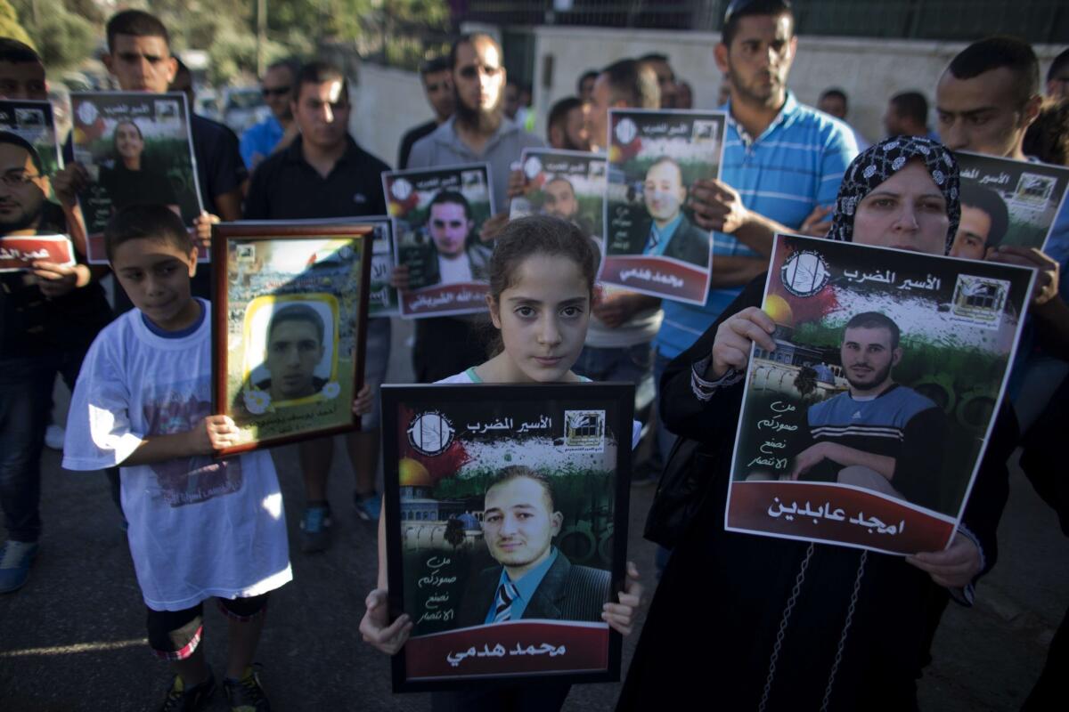 A file picture taken on June 12, shows a girl holding a placard of her relative during a demonstration to show solidarity with hunger-striking Palestinian prisoners held by Israel, outside the Red Cross building in east Jerusalem.
