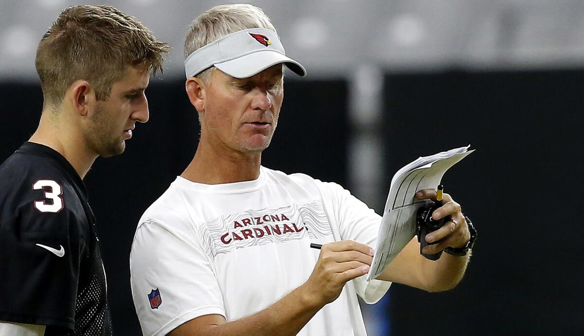 Cardinals offensive coordinator Mike McCoy explains a play to rookie quarterback Josh Rosen (3) during training camp in August.
