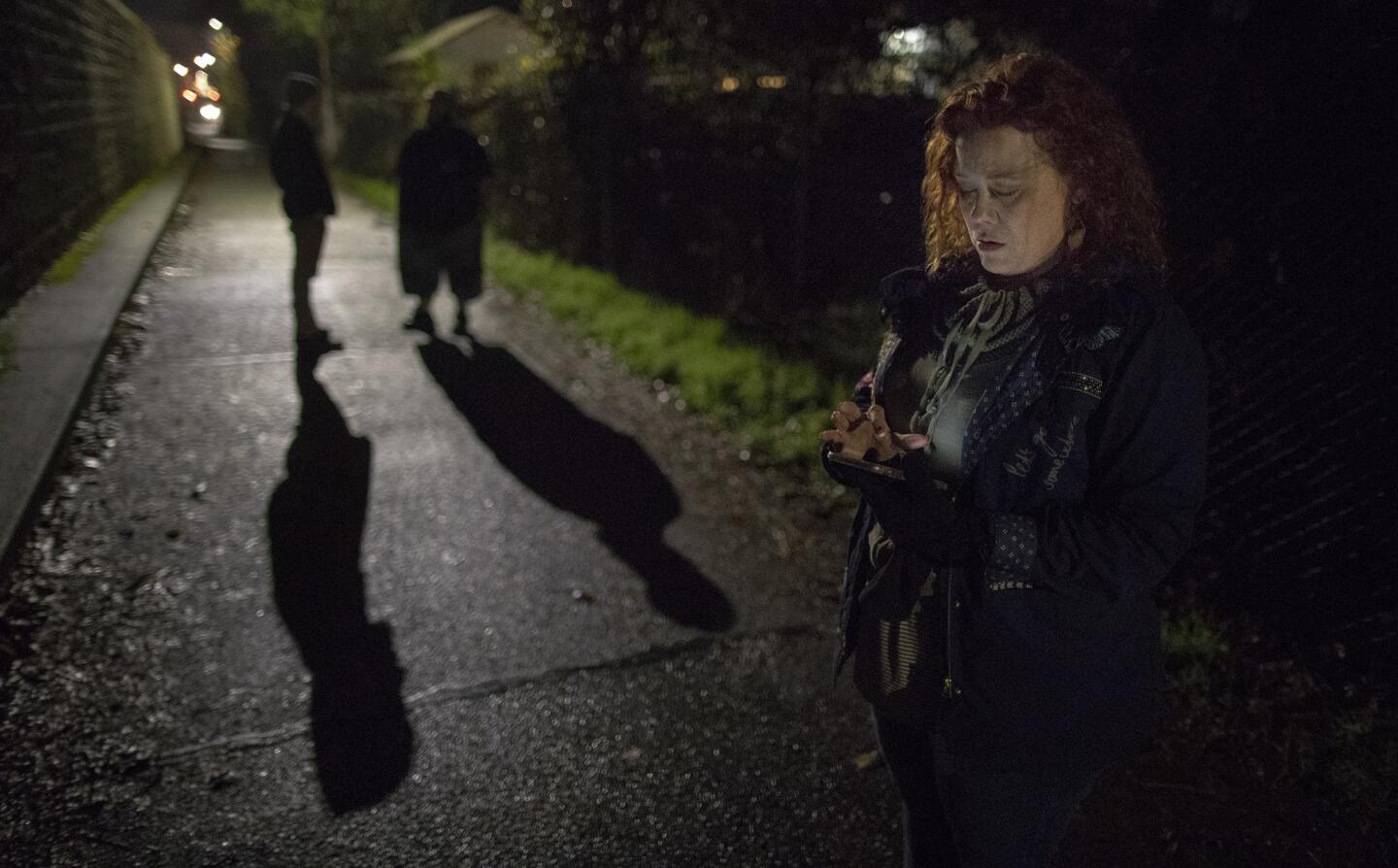 Montavilla Initiative chairwoman Angela Todd sends a text message while on patrol along a multi-use path in a neighborhood where a homeless encampment was recently cleared in Portland, Ore.