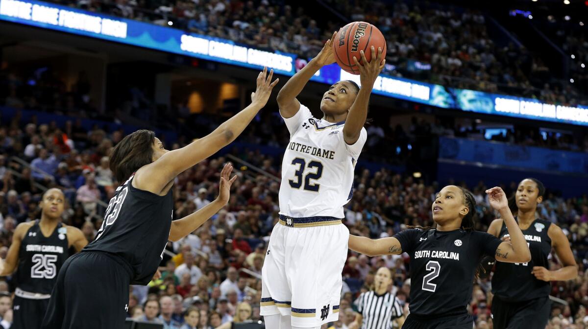 Notre Dame All-American guard Jewell Loyd goes up for a shot against South Carolina guard Tina Roy (23) in the second half while other Gamecocks look on.