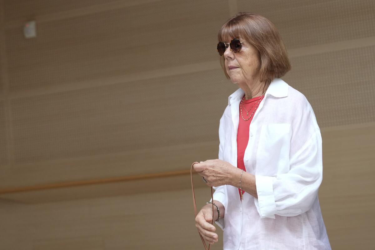 A woman wearing sunglasses arrives in court. 