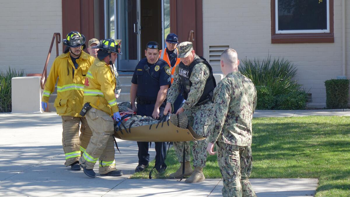 U.S. Navy Security Forces and Department of Defense firefighters carry a sailor during an active shooter drill Tuesday at Naval Weapons Station Seal Beach.