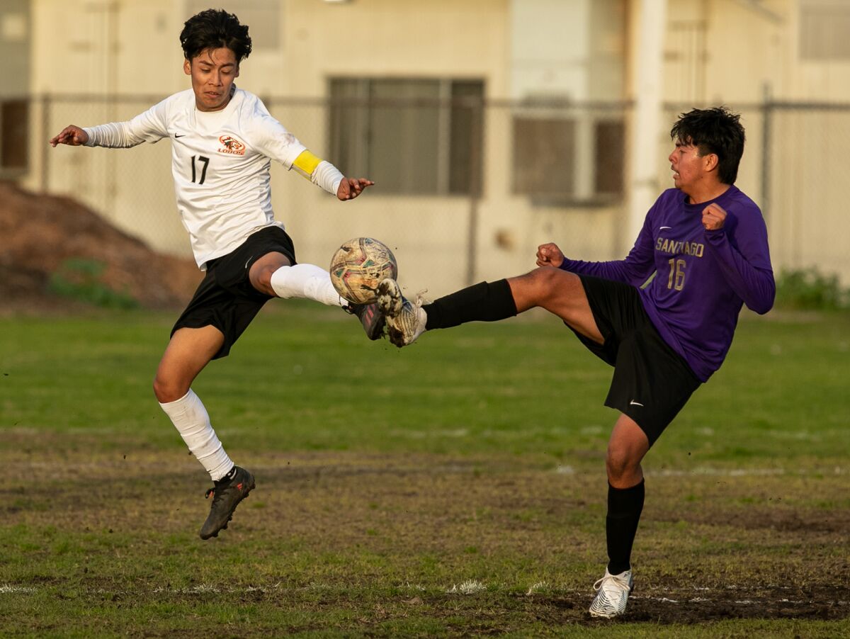 Los Amigos' Anthony Gutierrez and Santiago's Fabian Barajas battle for a ball in a Garden Grove League boys' soccer match.