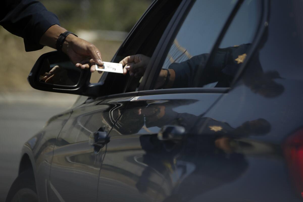 An officer handing a motorist a document.