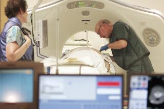 Dr. Steven Birnbaum works with a patient in a CT scanner at Southern New Hampshire Medical Center in Nashua, N.H.