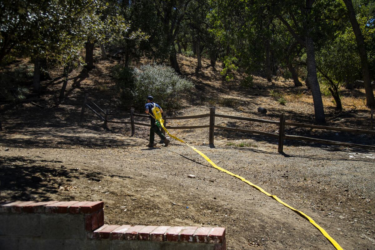 A firefighter lays out a fire hose.