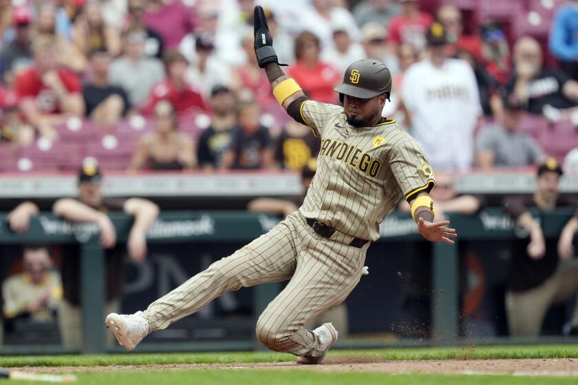 San Diego Padres second baseman Luis Arraez slides safely into home plate to score on a sacrifice fly hit by Jake Cronenworth in the 10th inning of a baseball game on Thursday, May 23, 2024, in Cincinnati. The Padres won 6-4 in 10 innings. (AP Photo/Carolyn Kaster)