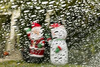 Raindrops on a windshield obscure Christmas decorations in a Mar Vista Neighborhood on Dec. 18, 2023. Showers are expected on and off through the week.