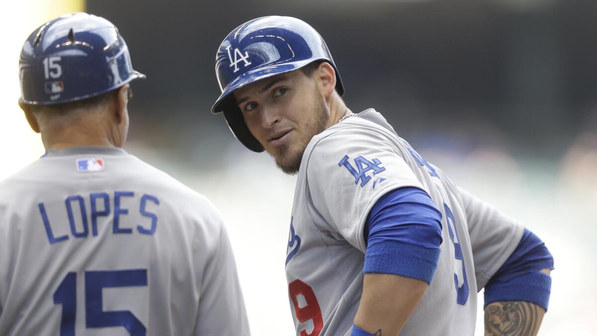 Dodgers catcher Yasmani Grandal, right, speaks with first base coach Davey Lopes after hitting a two-run single against the Milwaukee Brewers on May 7.