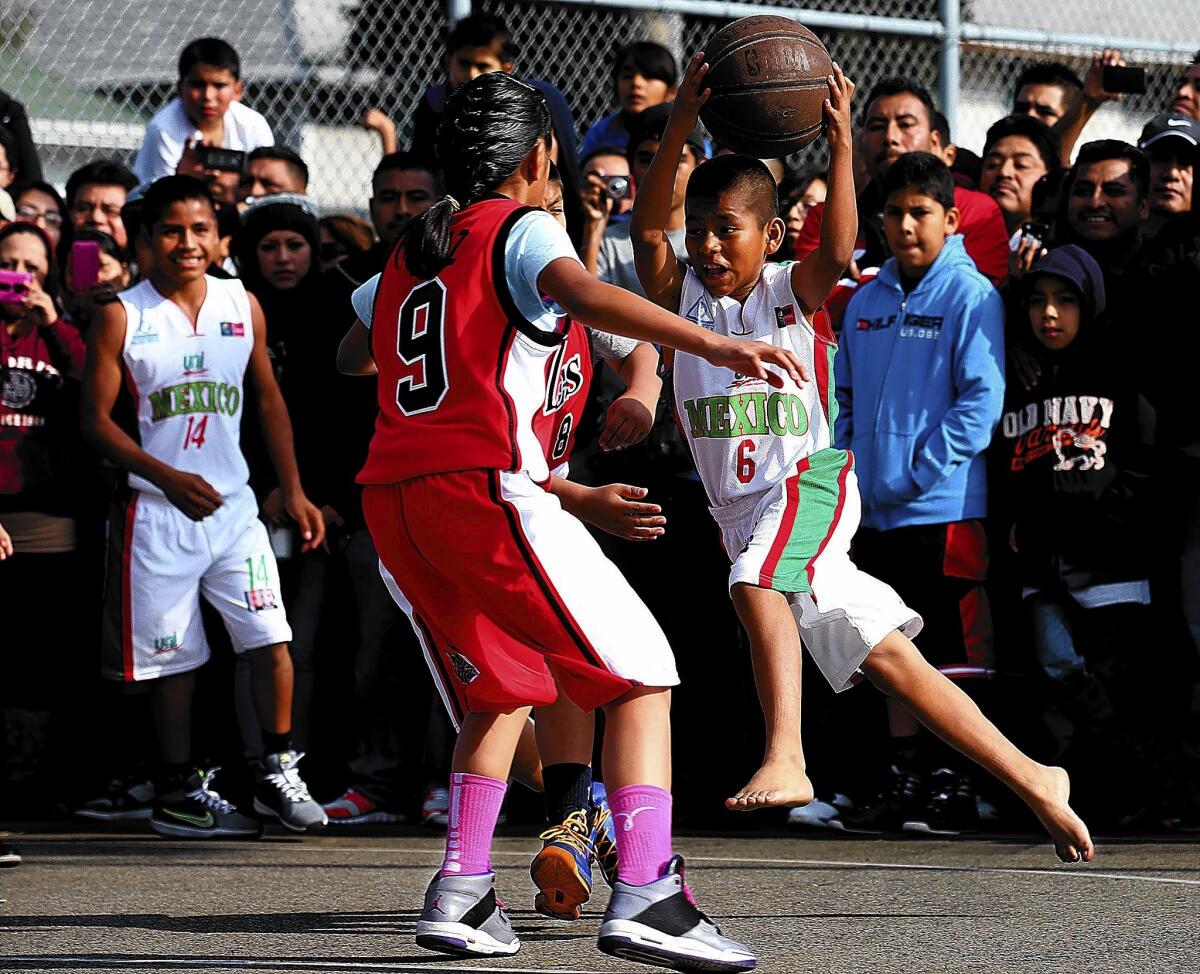 Melquiades Ramirez, a Ninos Triquis point guard, drives to the basket during the Oaxacan team's opening game of a youth basketball tournament at the Toberman Recreation Center in Los Angeles on Saturday.