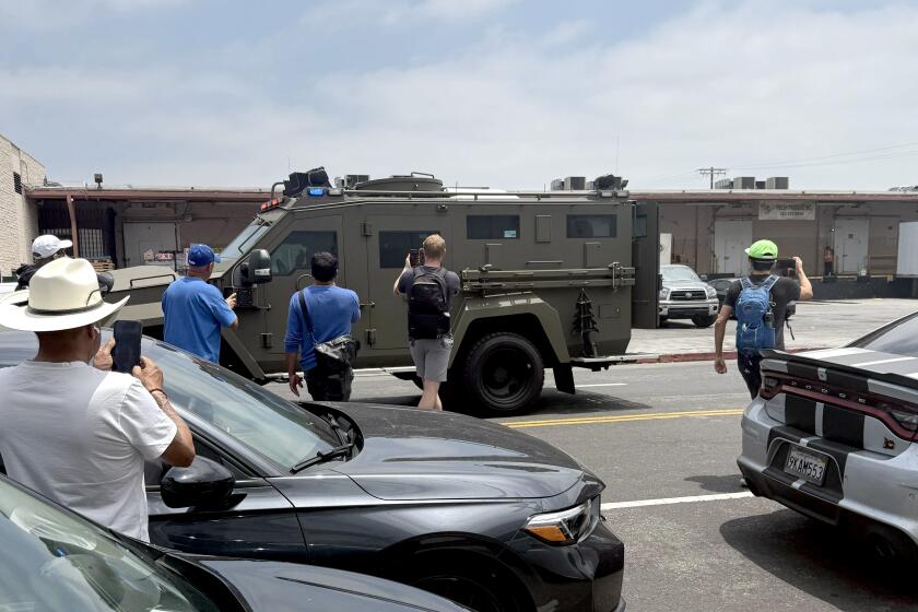 Los Angeles, CA June 6, 2025 - Protesters film federal agents as they leave the scene of an immigration raid Los Angeles, CA on Friday, June 6, 2025. (Rachel Uranga/Los Angeles Times)