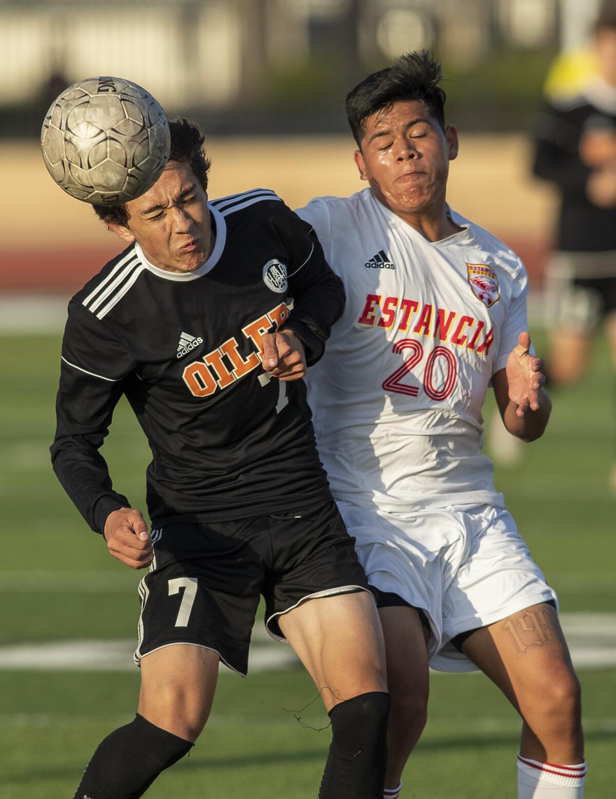 Huntington Beach's Carson Dykes and Estancia's Edwin Raymundo battle for a ball in a Division 2 boys' soccer playoff game.