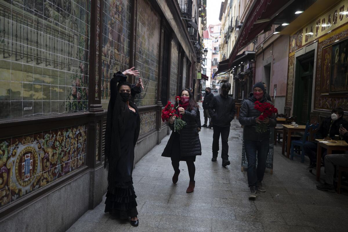 Spanish Flamenco dancer Anabel Moreno dances outside the Villa Rosa Tablao flamenco venue as a woman comes to give her a rose during a protest in Madrid, Spain, Thursday March 4, 2021. The National Association of Tablaos protested outside the mythical Villa Rosa Tablao which has been forced to close permanently due to the covid pandemic. (AP Photo/Paul White)
