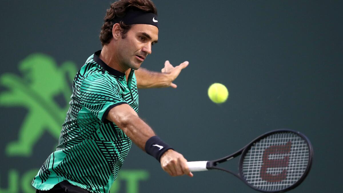Roger Federer volleys a shot against Nick Kyrgios during their semifinal match at the Miami Open on Friday in Key Biscayne, Fla.
