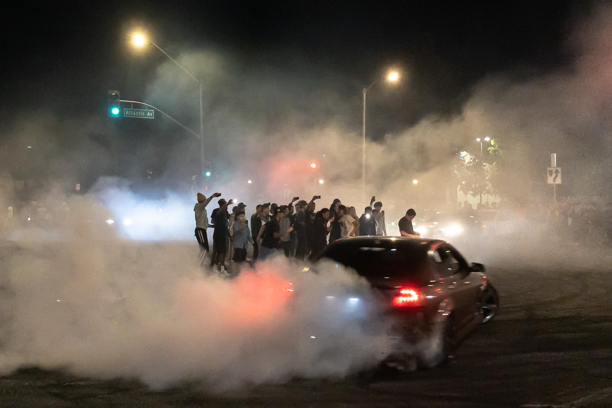A car drifts around spectators amid a close of smoke