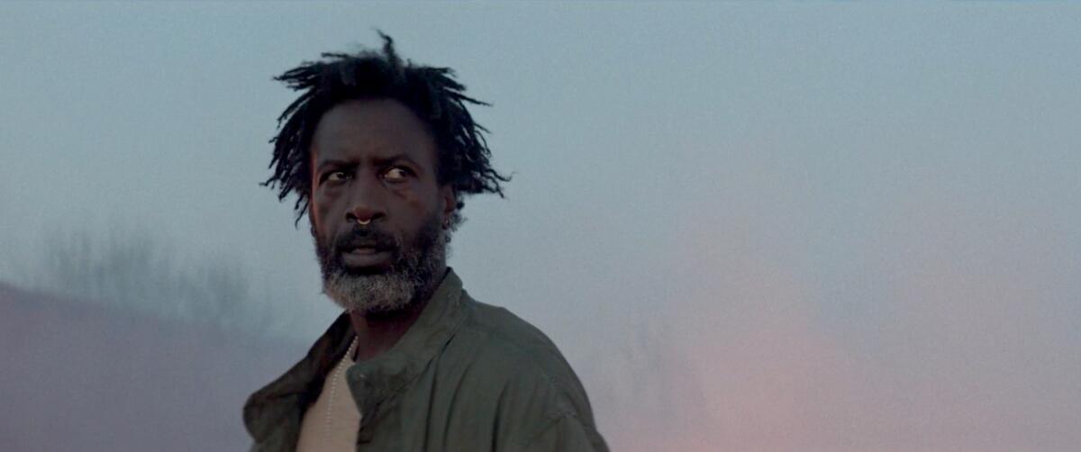 A man looks apprehensively to his left in movie "Akilla's Escape."