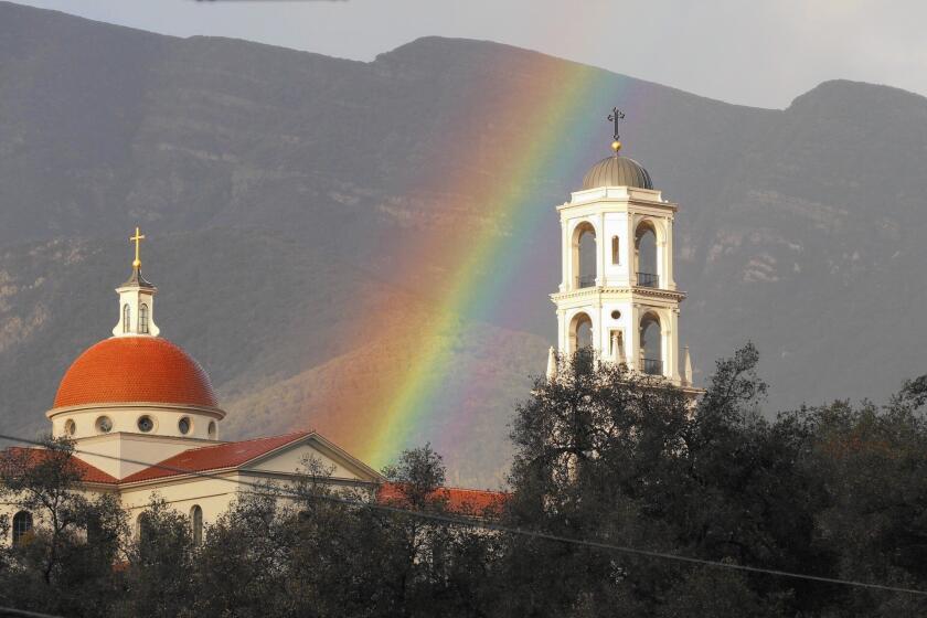 A rainbow appears to rise above Thomas Aquinas College in Santa Paula. Another storm system is forecast to hit Southern California on Saturday.
