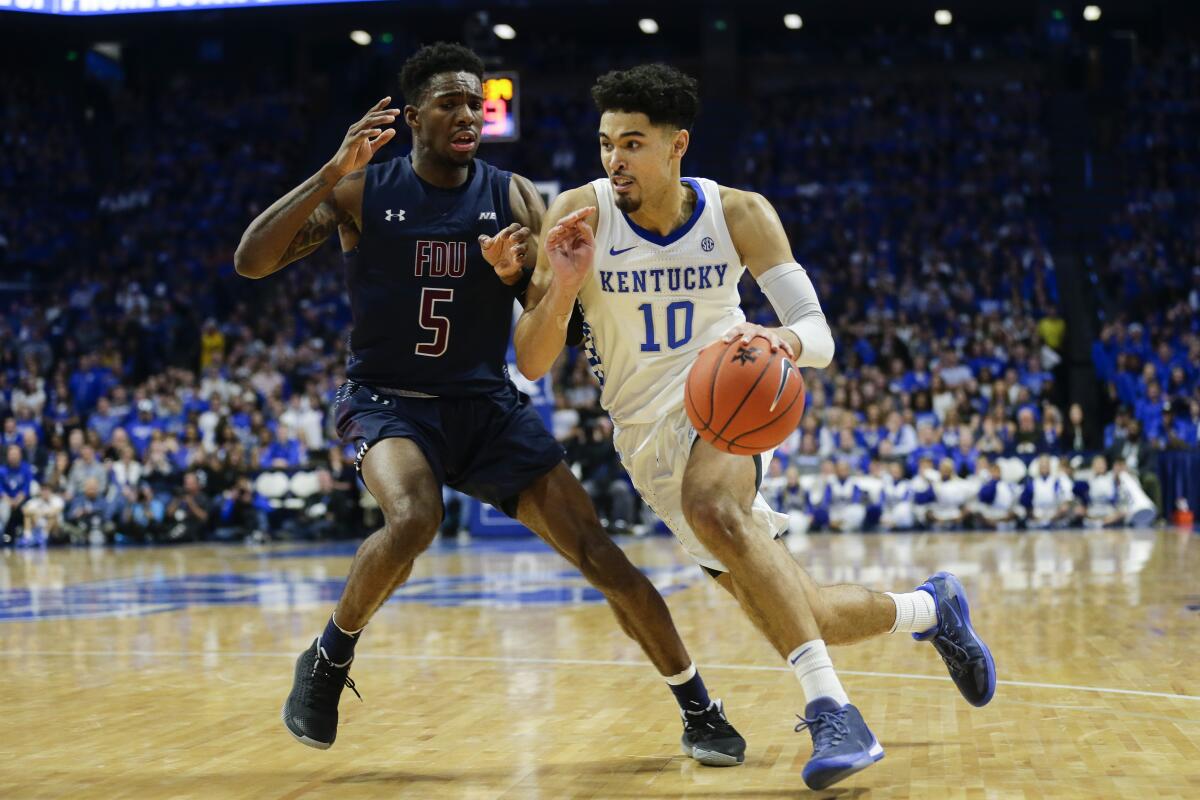 Johnny Juzang drives against Fairleigh Dickinson's Xzavier Malone-Key during a game for Kentucky. 