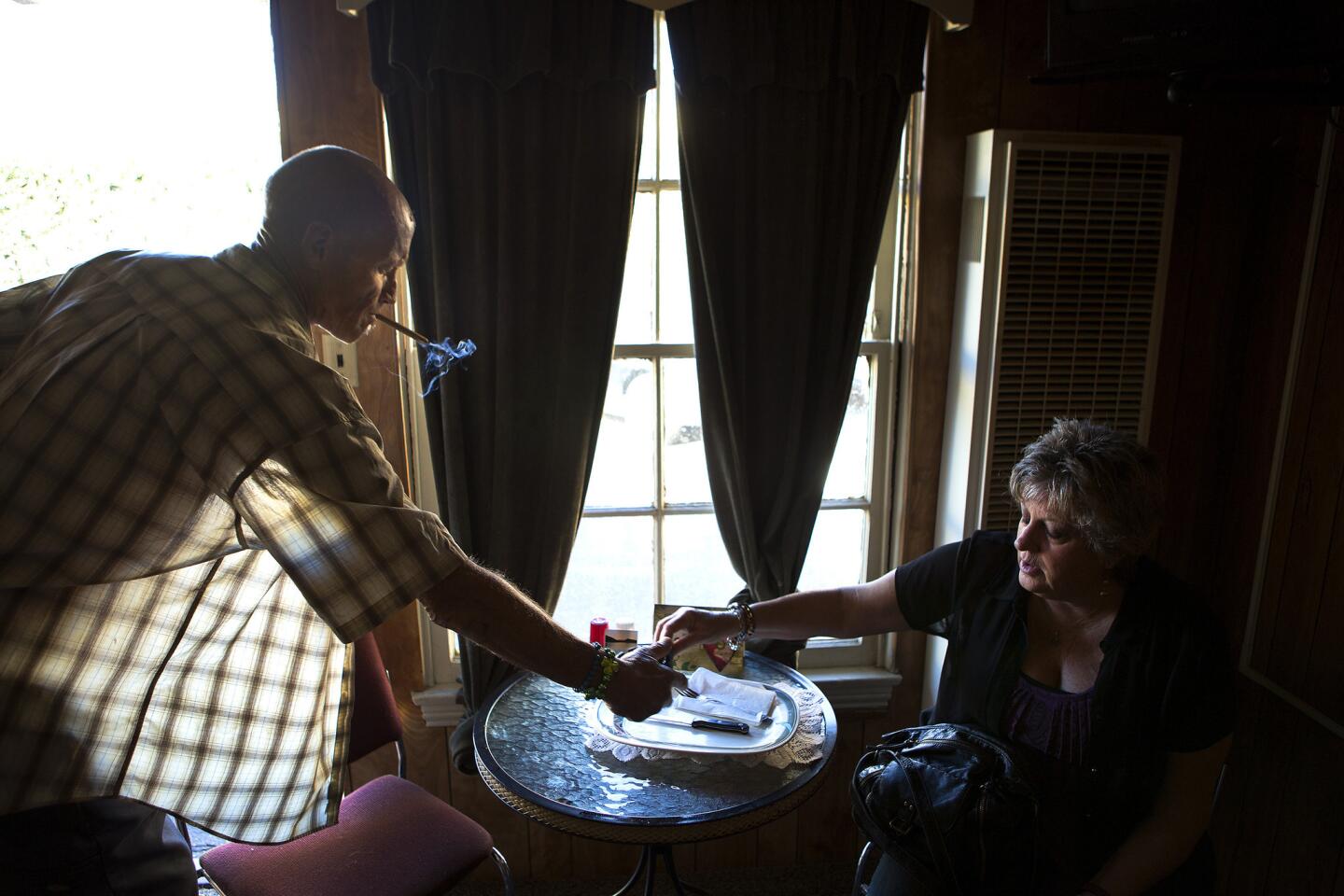 John Stephen Wood, a homeless carpenter who was born and raised in Ventura, takes an ashtray from church volunteer Kathy Powell. Caseworkers have tried over the years to give him assistance, but he rejected their offers.