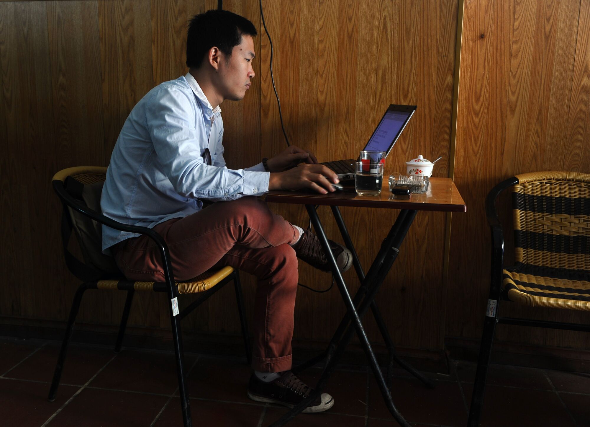 A man uses a laptop at a coffee shop in downtown Hanoi. 