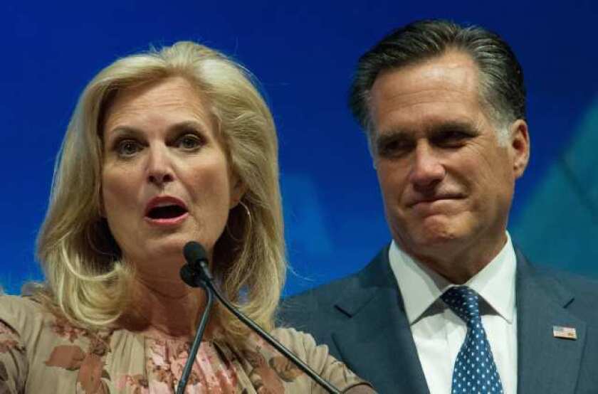 Mitt Romney listens to his wife Ann as she addresses the National Rifle Association Leadership Forum in St. Louis, Missouri.
