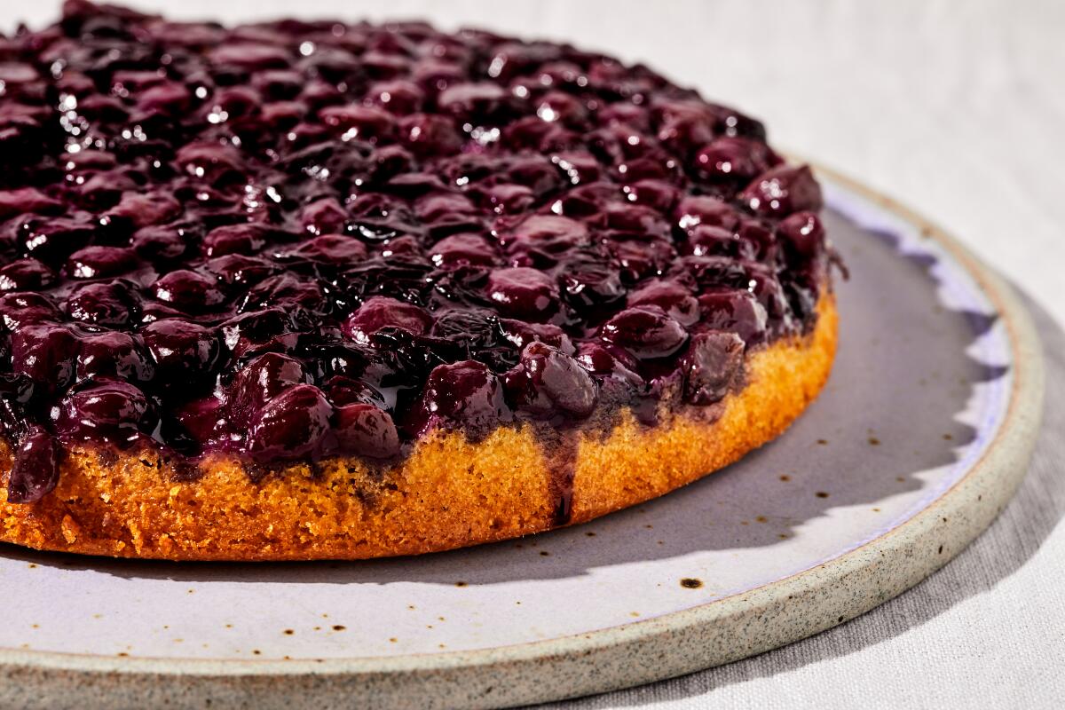 A round cake with a topping of baked jammy grapes