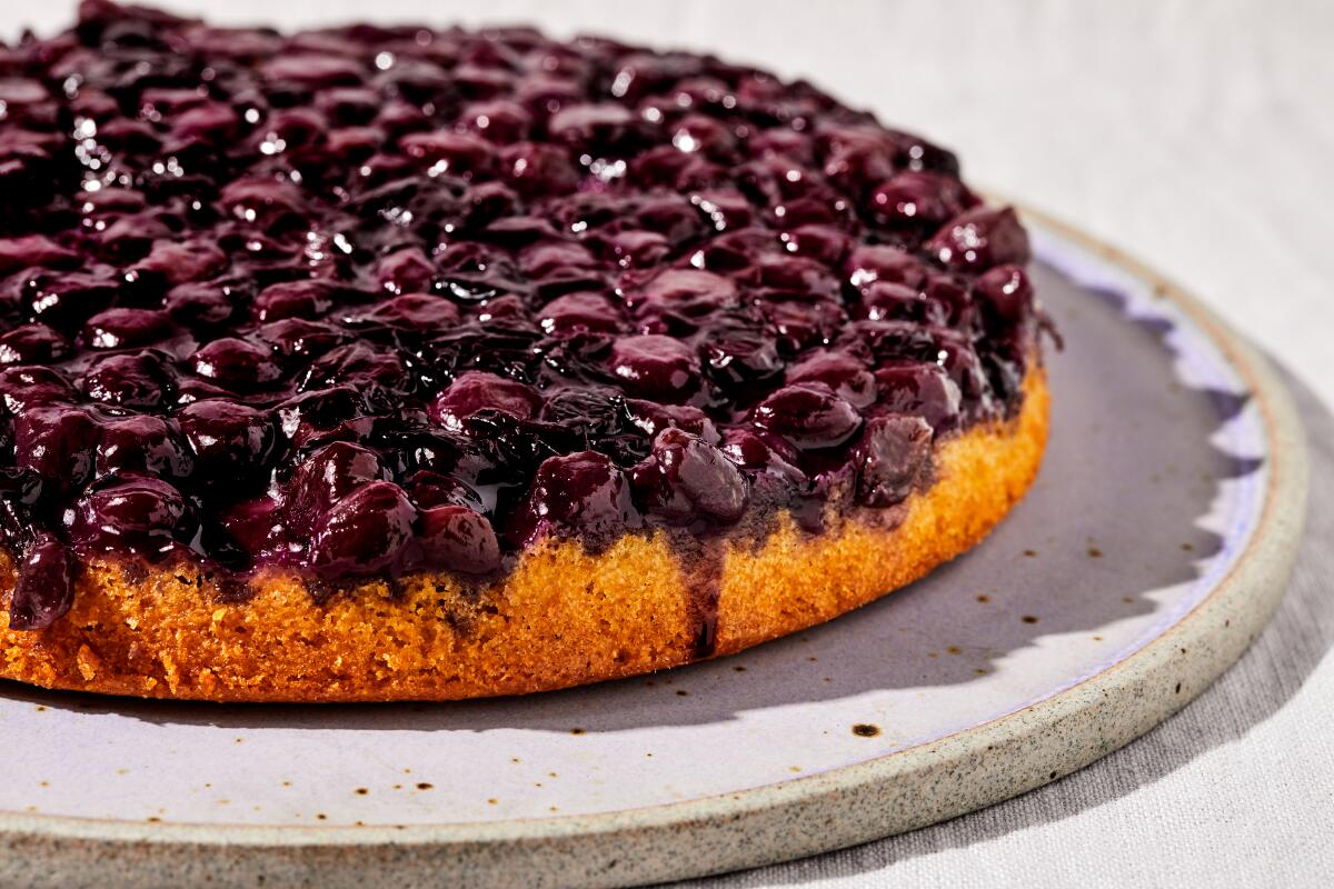 A round yellow cake topped with cooked fruit