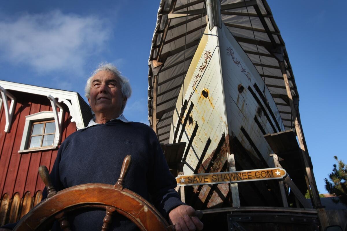 While holding on to the original wheel in 2012, Dennis Holland looks over his rebuilding efforts of the 72-foot Shawnee, parked in between his historic barn and home in Newport Beach. He died Monday at home. He was 68.