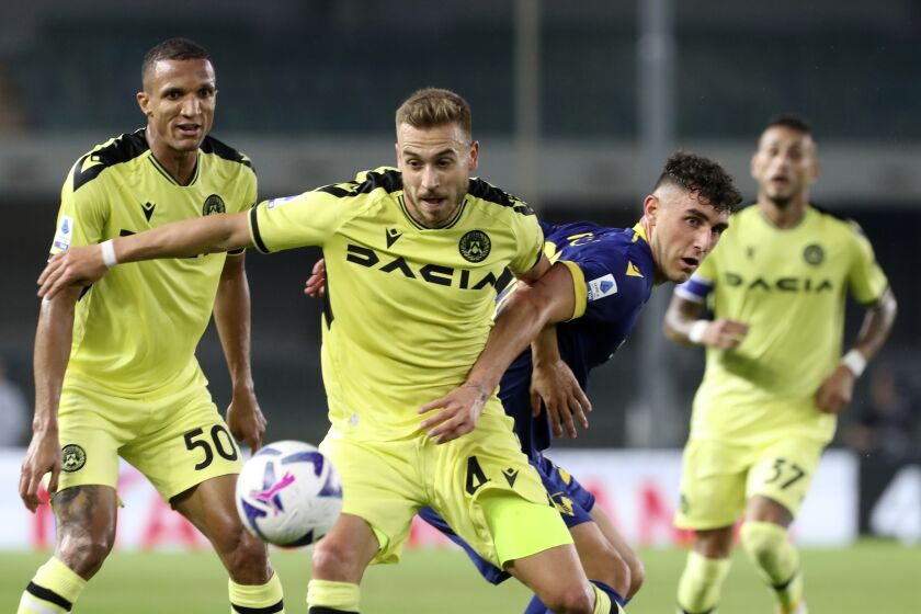 Udinese's Sandi Lovric, center, fights for the ball during the Serie A soccer match between Hellas Verona and Udinese, at Marcantonio Bentegodi stadium in Verona, Italy, Monday, Oct. 3, 2022. (Paola Garbuio/LaPresse via AP)