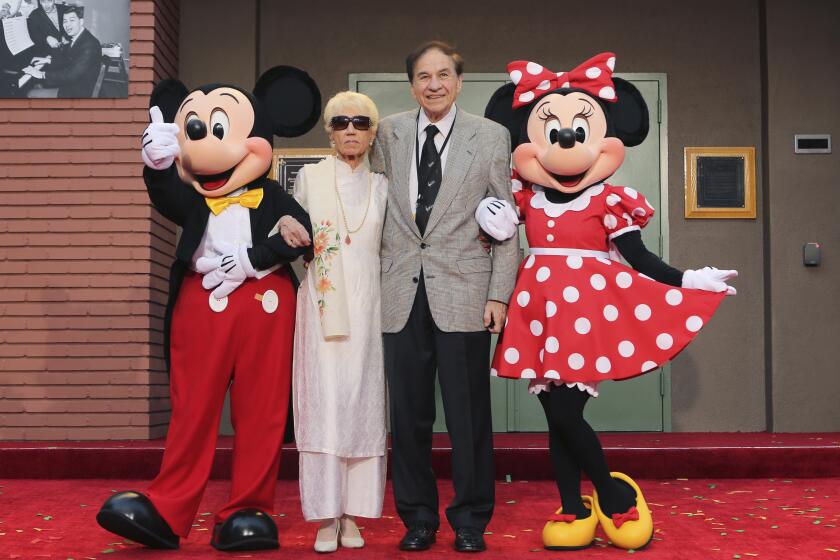 ARCHIVO - Mickey Mouse, de izquierda a derecha, Elizabeth Gluck, Richard M. Sherman y Minnie Mouse posan para una foto durante una ceremonia de homenaje a los hermanos Sherman en la que se renombró el Disney Studios Soundstage A durante el estreno mundial de "Christopher Robin" de Disney en Walt Disney Studios el 30 de julio de 2018 en Burbank, California. (Foto by Willy Sanjuan/Invision/AP, Archivo)